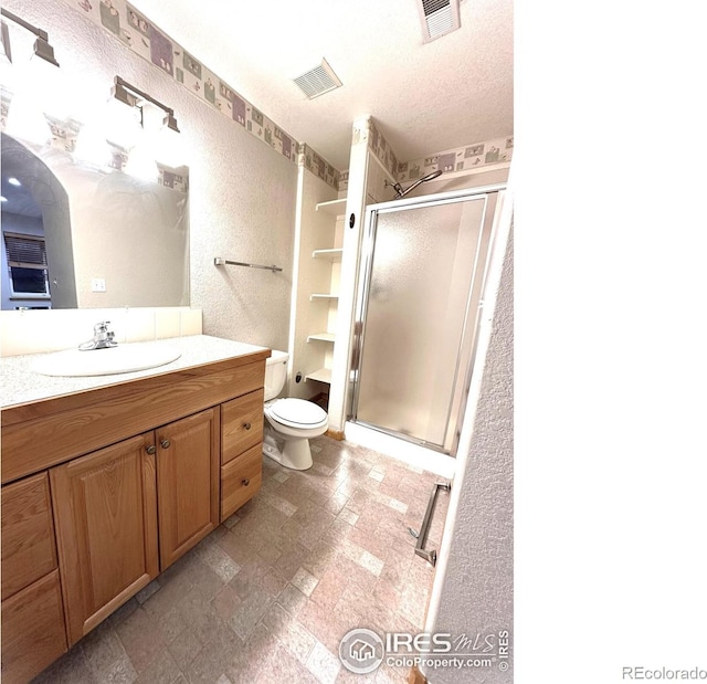 full bath with a stall shower, toilet, and vanity