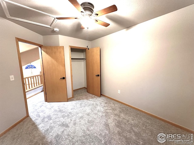 unfurnished bedroom with carpet floors, baseboards, and attic access