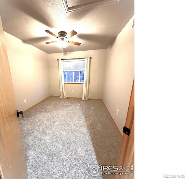 carpeted spare room with baseboards, ceiling fan, and a textured ceiling
