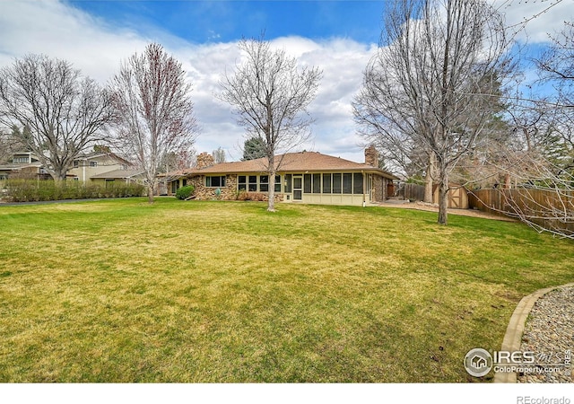 view of yard with a sunroom and fence