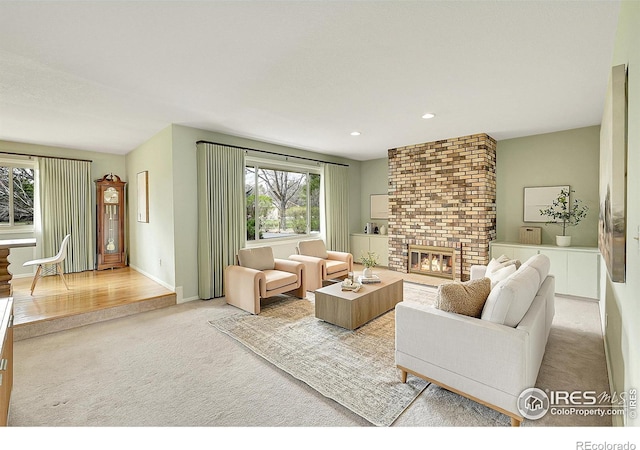 living area featuring recessed lighting, carpet flooring, a brick fireplace, and baseboards