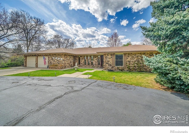 single story home with an attached garage, driveway, a front lawn, and brick siding