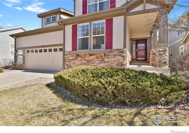 view of front of property with concrete driveway, stone siding, and an attached garage