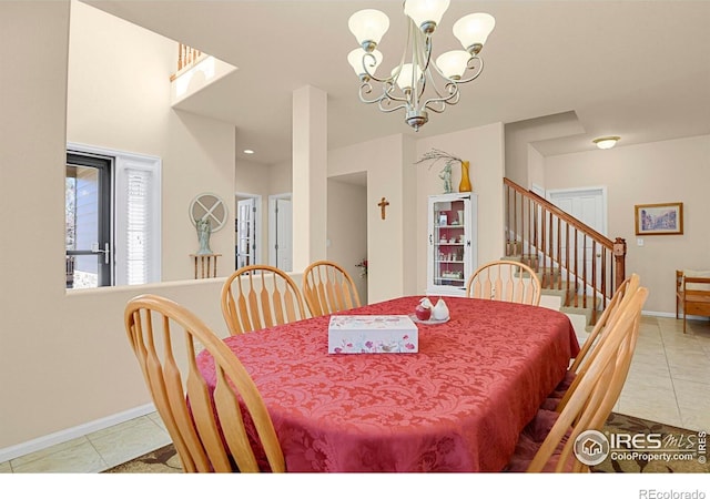 tiled dining space with baseboards, stairway, and an inviting chandelier