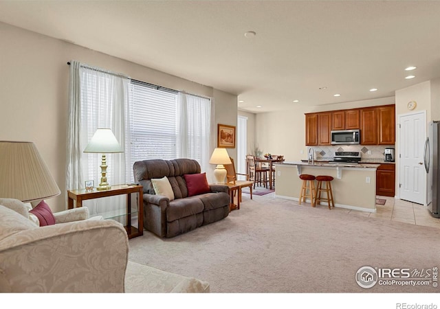 living area with light carpet and recessed lighting