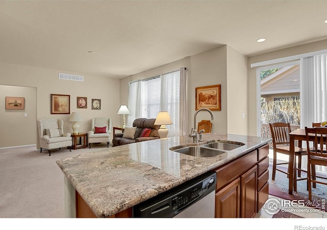 kitchen featuring stainless steel dishwasher, light stone countertops, dark carpet, visible vents, and a sink