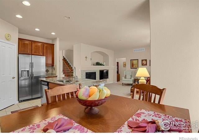 dining space with a glass covered fireplace, recessed lighting, visible vents, and light tile patterned flooring
