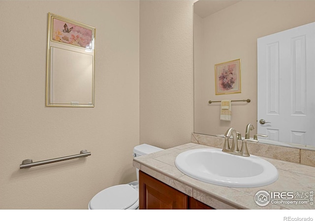 half bathroom with toilet and vanity
