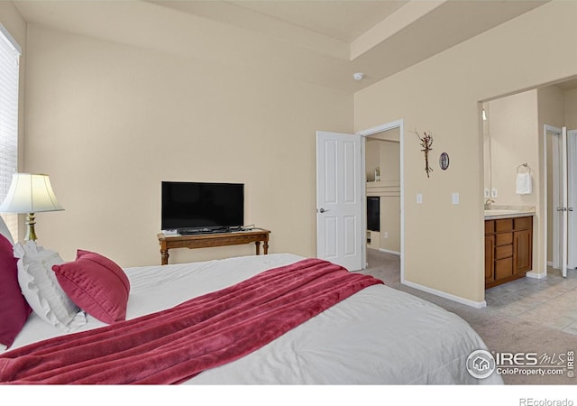 bedroom with light carpet, baseboards, and ensuite bath