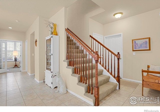 stairs featuring tile patterned floors and baseboards