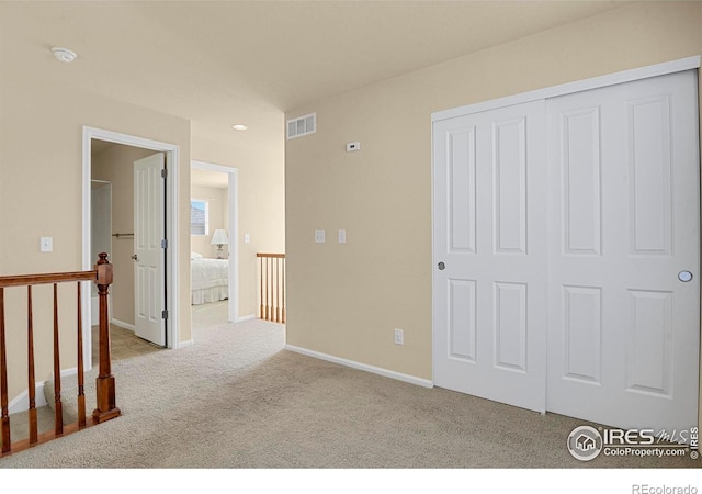 interior space featuring visible vents, baseboards, a closet, and carpet floors