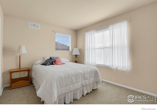 carpeted bedroom with visible vents and baseboards