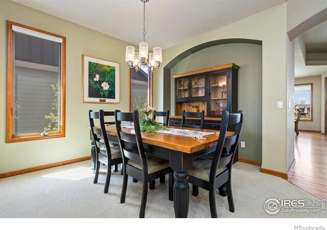 6741 Bandon Dunes Dr, Windsor, CO 80550 - dining space with light carpet, a notable chandelier, and baseboards