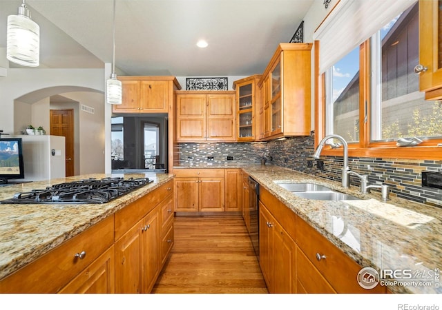6741 Bandon Dunes Dr, Windsor, CO 80550 - kitchen with hanging light fixtures, black dishwasher, a sink, light stone countertops, and gas cooktop