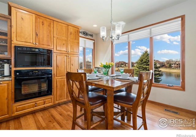 6741 Bandon Dunes Dr, Windsor, CO 80550 - dining area featuring visible vents, baseboards, a chandelier, and light wood-style floors