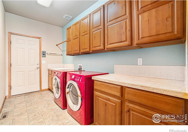 6741 Bandon Dunes Dr, Windsor, CO 80550 - laundry room with cabinet space, visible vents, washer and clothes dryer, and a sink