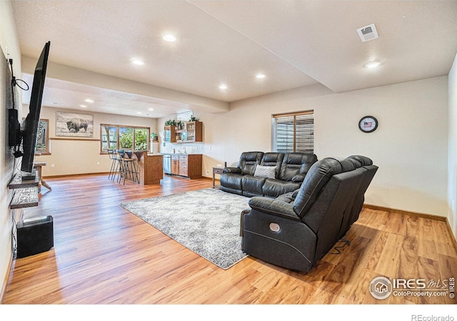 6741 Bandon Dunes Dr, Windsor, CO 80550 - living room featuring wood finished floors, baseboards, visible vents, and recessed lighting