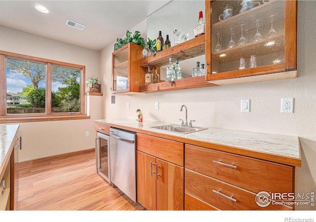6741 Bandon Dunes Dr, Windsor, CO 80550 - kitchen featuring light countertops, visible vents, brown cabinets, dishwasher, and a sink