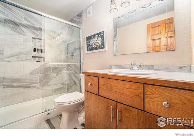 6741 Bandon Dunes Dr, Windsor, CO 80550 - bathroom featuring toilet, vanity, a shower stall, and visible vents