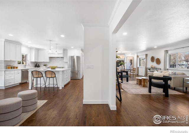 545 S Harrison Ln, Denver, CO 80209 - kitchen featuring a breakfast bar area, stainless steel appliances, open floor plan, and a wealth of natural light