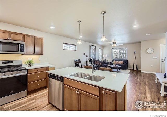 61 Avocet Ct, Longmont, CO 80501 - kitchen featuring stainless steel appliances, a sink, light countertops, pendant lighting, and light wood-type flooring