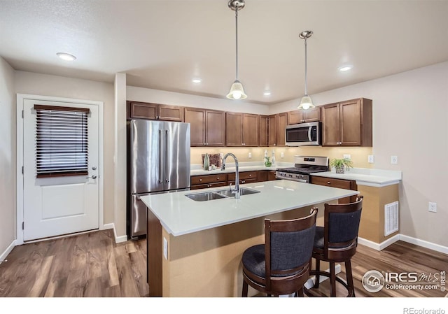 61 Avocet Ct, Longmont, CO 80501 - kitchen with stainless steel appliances, a sink, wood finished floors, baseboards, and light countertops