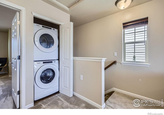 61 Avocet Ct, Longmont, CO 80501 - laundry area featuring stacked washer / dryer, carpet flooring, and baseboards