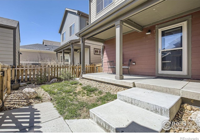61 Avocet Ct, Longmont, CO 80501 - doorway to property with covered porch and fence