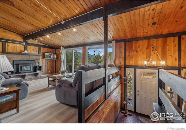 712 Aspen Dr, Lyons, CO 80540 - living area with track lighting, wood walls, wood ceiling, vaulted ceiling with beams, and wood finished floors