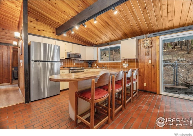 712 Aspen Dr, Lyons, CO 80540 - kitchen featuring butcher block counters, wood walls, wooden ceiling, and stainless steel appliances