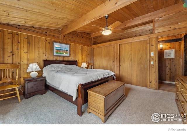 712 Aspen Dr, Lyons, CO 80540 - bedroom featuring two closets, wood ceiling, wooden walls, beamed ceiling, and light carpet