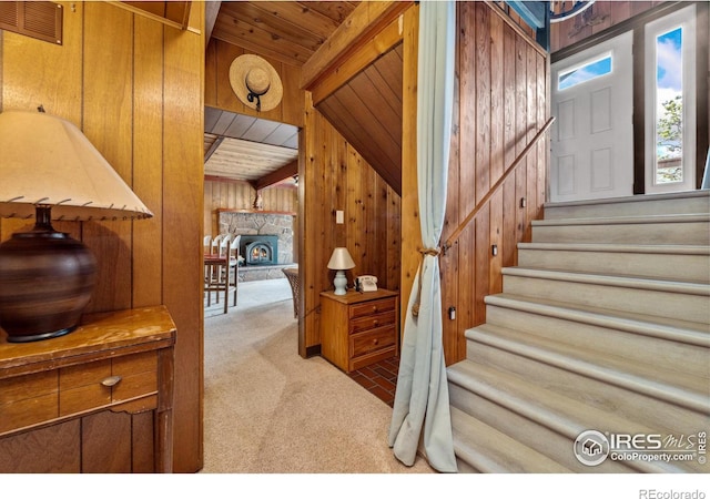712 Aspen Dr, Lyons, CO 80540 - stairway with wood ceiling, wooden walls, beam ceiling, and carpet