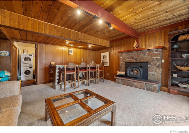 712 Aspen Dr, Lyons, CO 80540 - living area featuring stacked washer / dryer, wood ceiling, beamed ceiling, wood walls, and carpet flooring