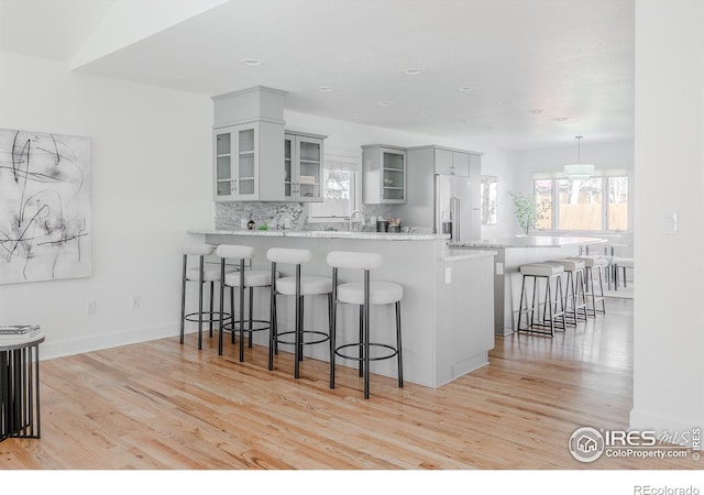 1835 Columbine Ave, Boulder, CO 80302 - kitchen with a peninsula, a breakfast bar, a healthy amount of sunlight, high end refrigerator, and tasteful backsplash