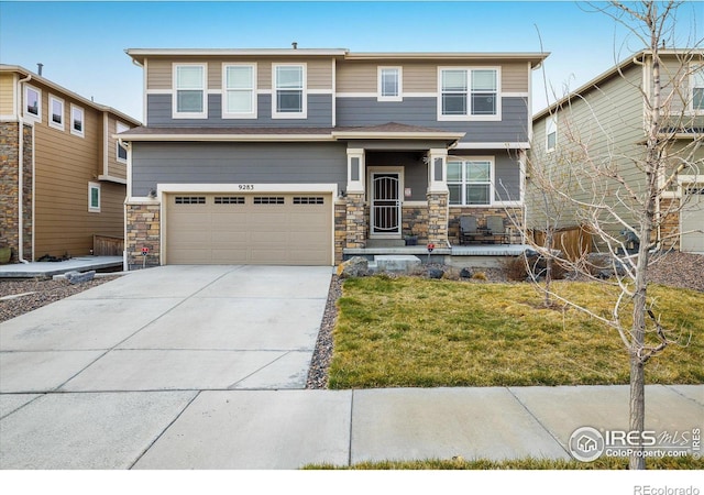 9283 Sedalia St, Commerce City, CO 80022 - view of front of home with an attached garage, driveway, stone siding, and a front lawn