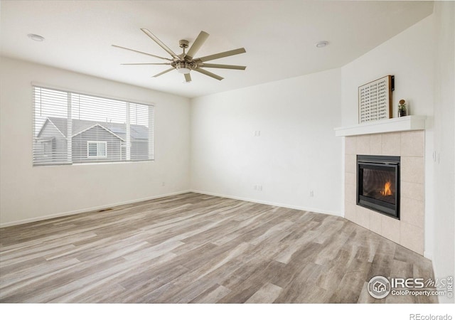 9283 Sedalia St, Commerce City, CO 80022 - unfurnished living room featuring a tiled fireplace, light wood-type flooring, baseboards, and ceiling fan