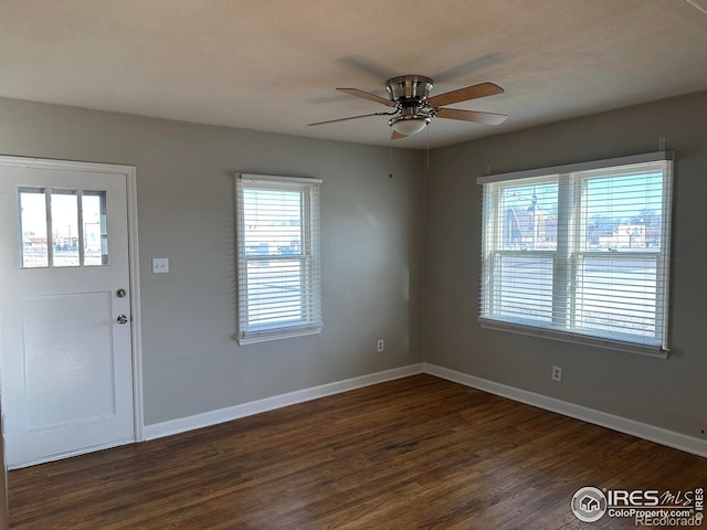 entrance foyer with dark wood-type flooring, ceiling fan, and baseboards
