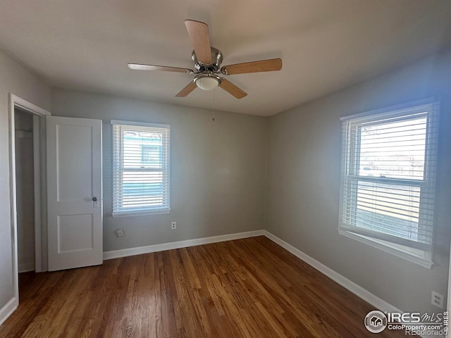 empty room with baseboards, a ceiling fan, and wood finished floors