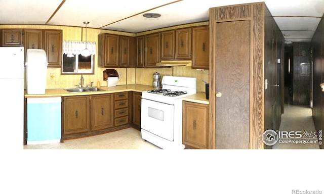 317 N Ord St, Grover, CO 80729 - kitchen featuring a sink, light countertops, white appliances, under cabinet range hood, and brown cabinetry