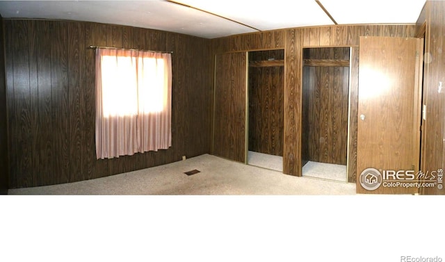 317 N Ord St, Grover, CO 80729 - unfurnished bedroom featuring carpet flooring, two closets, and wooden walls