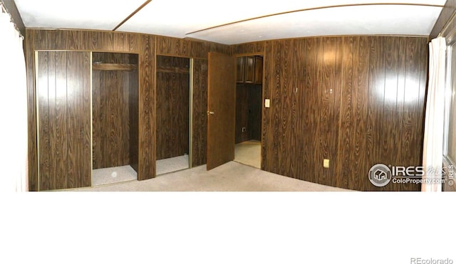 317 N Ord St, Grover, CO 80729 - unfurnished bedroom featuring two closets, wood walls, and carpet floors