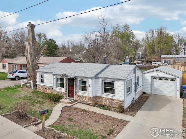 800 W 10th St, Loveland, CO 80537 - view of front of home with a detached garage, stone siding, an outdoor structure, concrete driveway, and roof with shingles