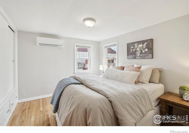 800 W 10th St, Loveland, CO 80537 - bedroom with light wood-style floors, a wall mounted AC, and baseboards