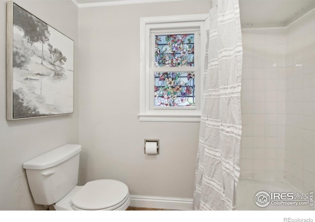 800 W 10th St, Loveland, CO 80537 - bathroom featuring toilet, baseboards, and a tile shower