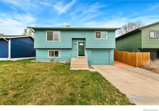 8205 Hallett Ct, Fort Collins, CO 80528 - split foyer home with a front yard, driveway, fence, and an attached garage