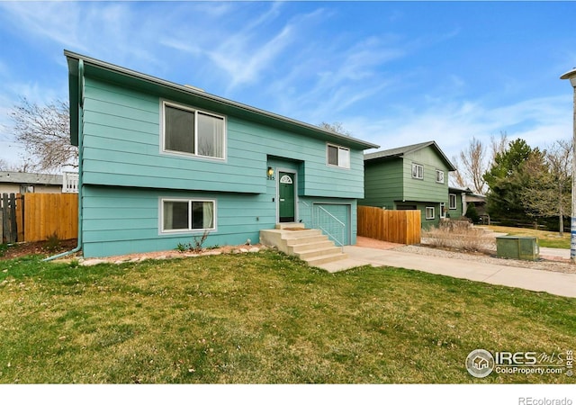 8205 Hallett Ct, Fort Collins, CO 80528 - split foyer home with an attached garage, concrete driveway, fence, and a front lawn