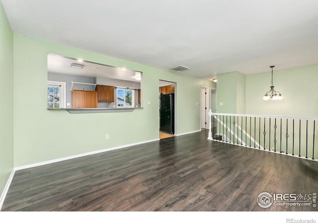 8205 Hallett Ct, Fort Collins, CO 80528 - unfurnished living room featuring a notable chandelier, visible vents, baseboards, and dark wood-style floors