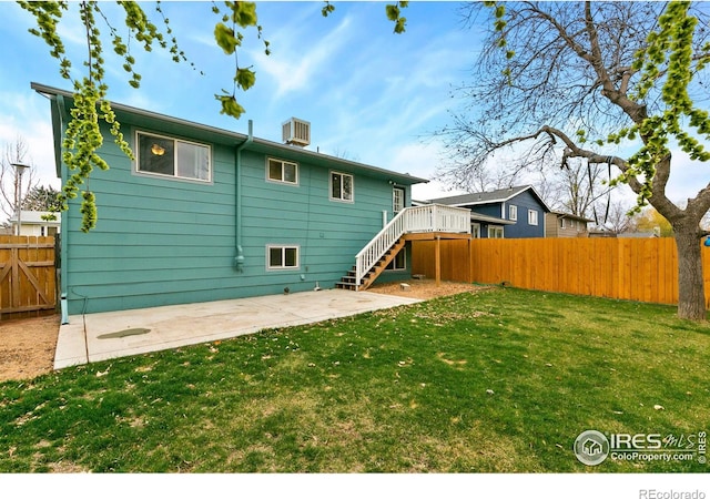 8205 Hallett Ct, Fort Collins, CO 80528 - back of house featuring a fenced backyard, stairway, a patio, and a lawn