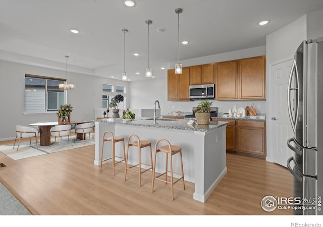 1103 Hornet Dr, Fort Collins, CO 80526 - kitchen with a sink, appliances with stainless steel finishes, light wood finished floors, and brown cabinets