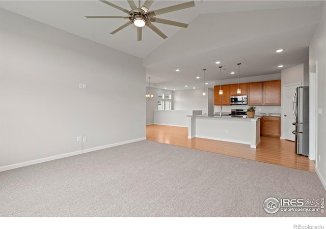 1103 Hornet Dr, Fort Collins, CO 80526 - kitchen with ceiling fan, light carpet, appliances with stainless steel finishes, open floor plan, and brown cabinets